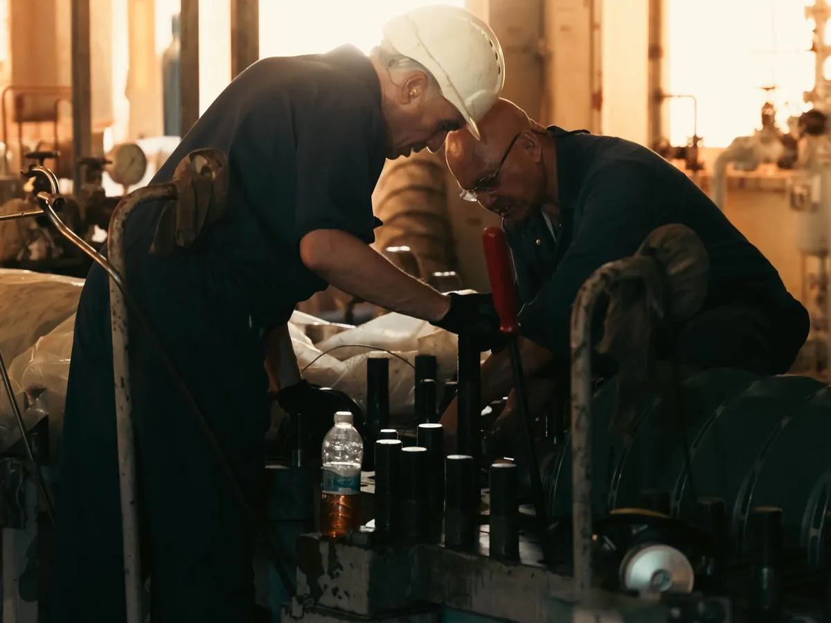 Maintenance engineers servicing industrial machinery in a plant